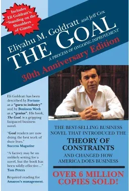 Front cover of the 30th Anniversary Edition of The Goal by Eliyahu M. Goldratt and Jeff Cox, subtitled A Process of Ongoing Improvement. A blue and white cover with a photograph of Goldratt seated at a desk, press quotes down the left side, and the strapline The Best-Selling Business Novel That Introduced the Theory of Constraints and Changed How America Does Business, above a red banner reading Over 6 Million Copies Sold.